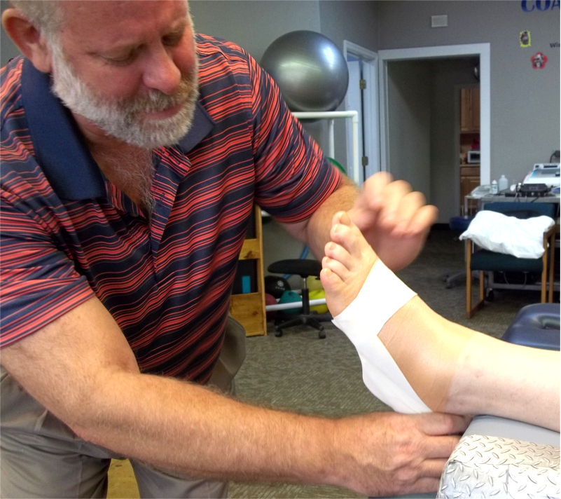Therapist Applying Athletic Tape to Patient Foot